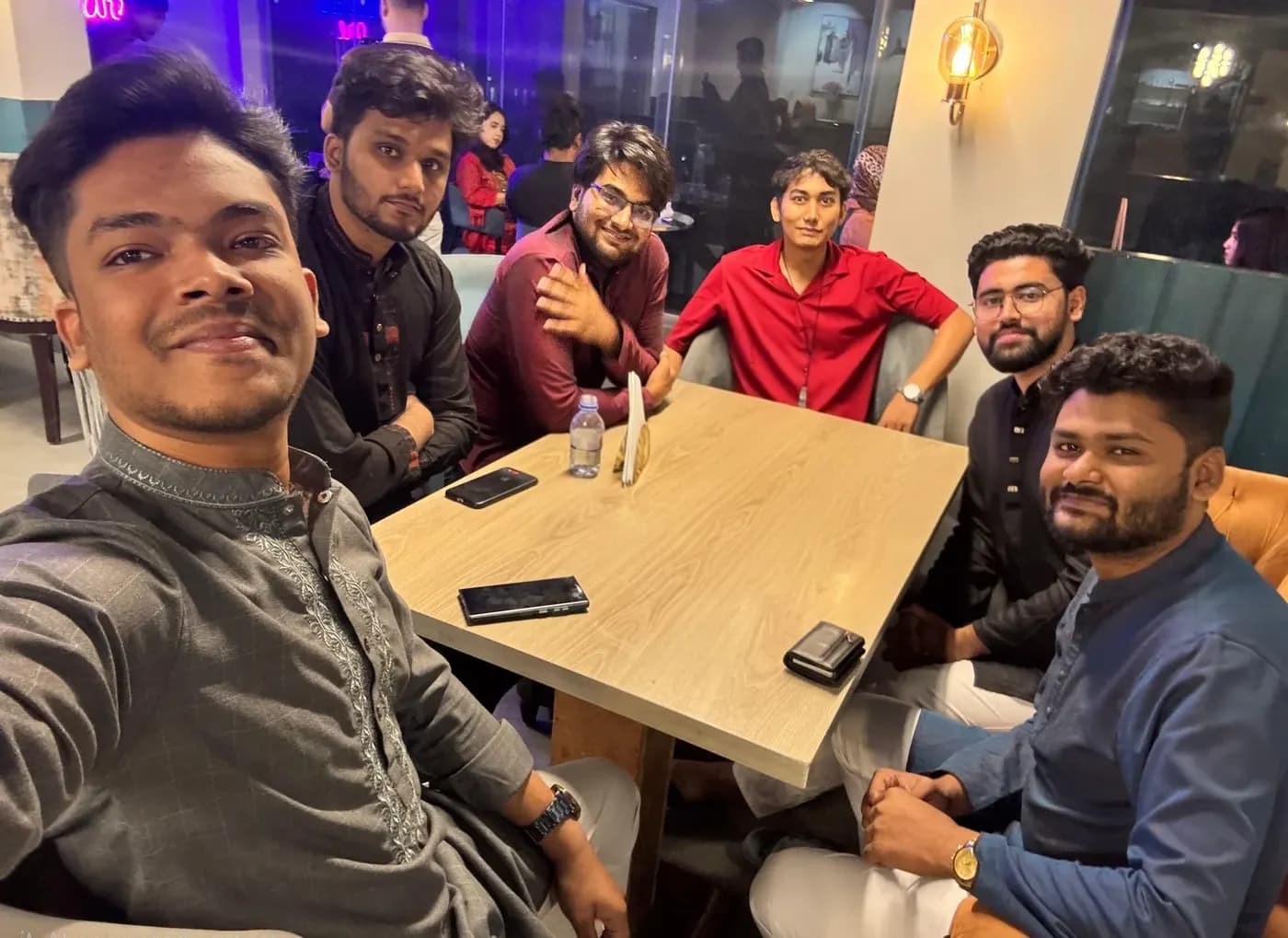 The whole CodeMyPixel team crowded around a table at a casual meetup.